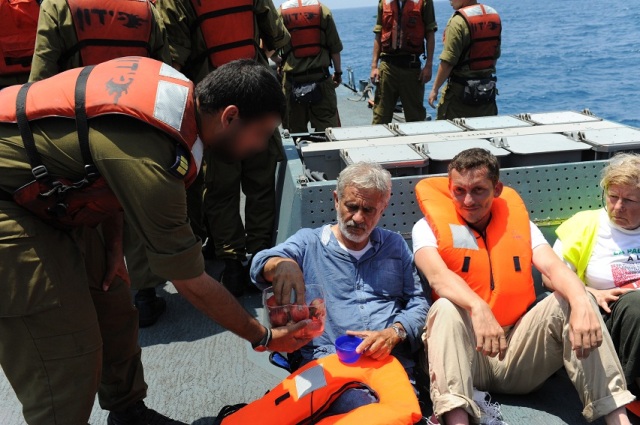 Al-Karama Passenger accepts food and water given to him by an IDF Navy soldier
